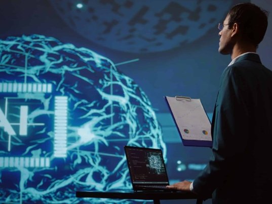 Startup employee looking over business charts, using AI software to take data driven decisions in tech industry. IT expert developing innovative artificial intelligence solutions for company, camera B